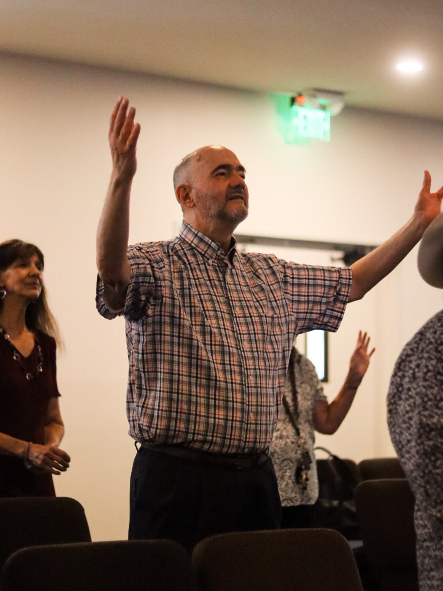 Worshipper with hands raised at Fountain of Life